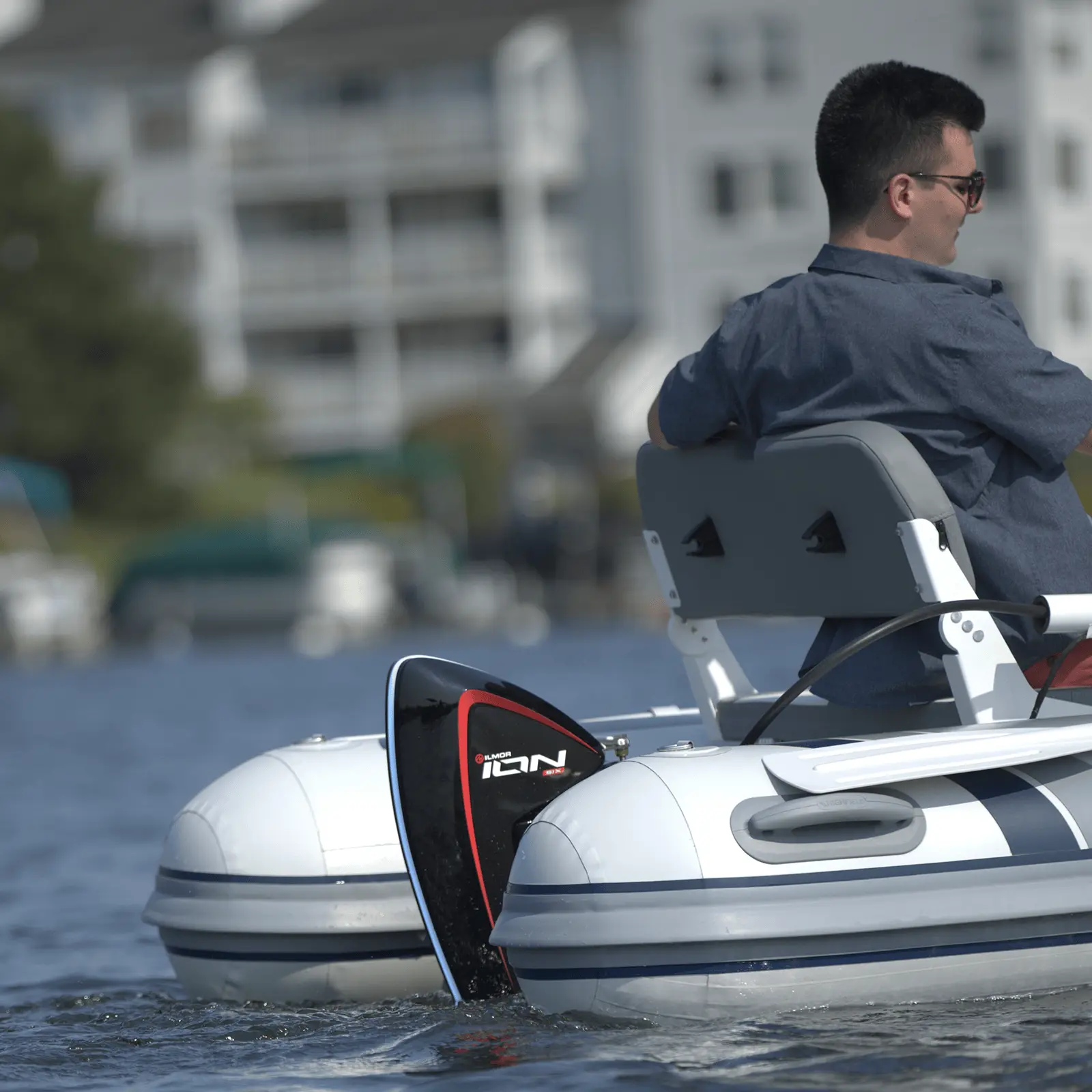 Ilmor ION electric outboard on a small inflatable boat, with a man at the helm