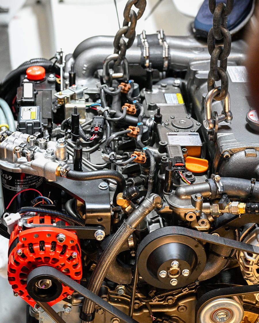 A new YANMAR marine diesel on a chain hoist, close up
